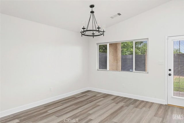 unfurnished dining area featuring an inviting chandelier, visible vents, light wood finished floors, and baseboards