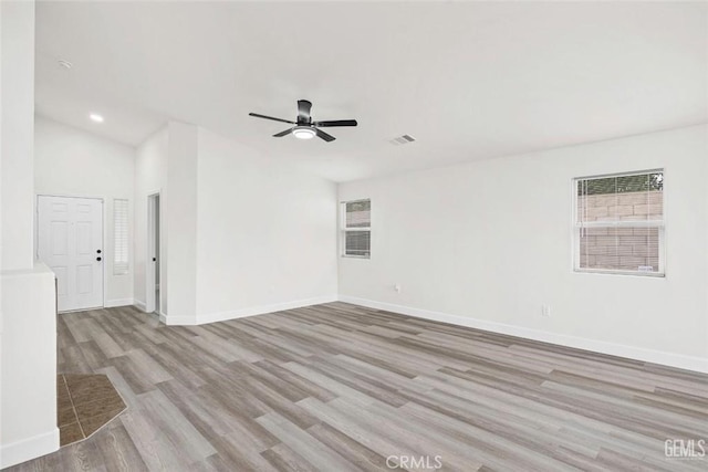 spare room featuring baseboards, a healthy amount of sunlight, visible vents, and light wood-type flooring