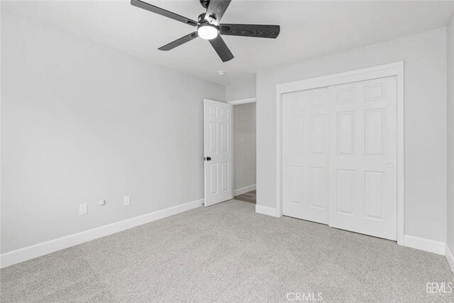 unfurnished bedroom with ceiling fan, baseboards, a closet, and carpet