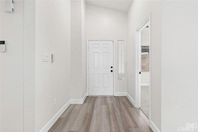 hall featuring baseboards and wood finished floors