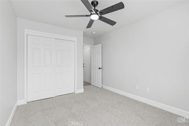 unfurnished bedroom with baseboards, a closet, and carpet flooring