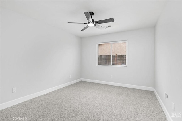 carpeted spare room with ceiling fan, baseboards, and visible vents