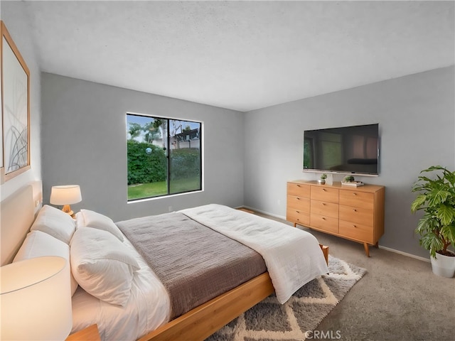 bedroom featuring light carpet and baseboards