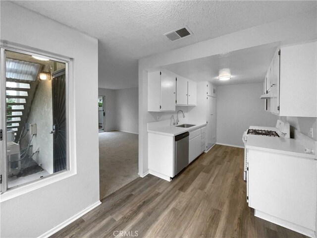 1800 E Old Ranch Rd, Colton, CA 92324 - kitchen with stainless steel dishwasher, light countertops, baseboards, dark wood-style flooring, and a textured ceiling