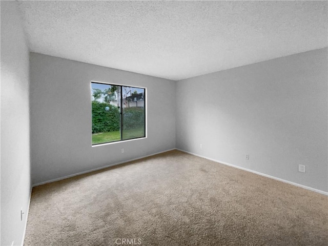 unfurnished room with carpet floors, a textured ceiling, and baseboards