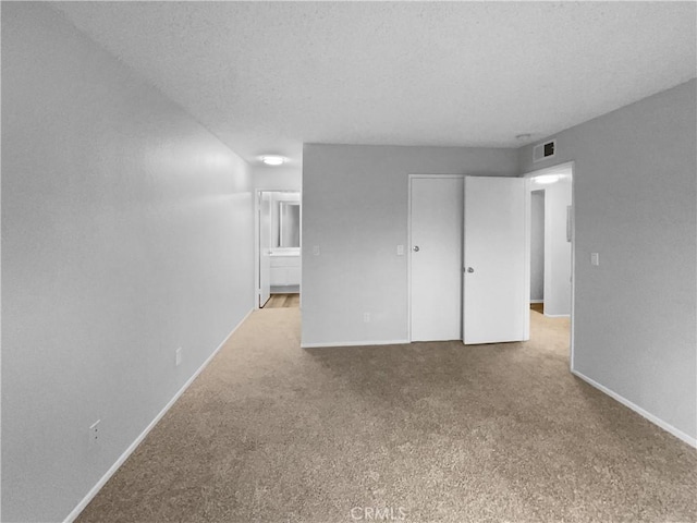 interior space featuring a textured ceiling, visible vents, and baseboards