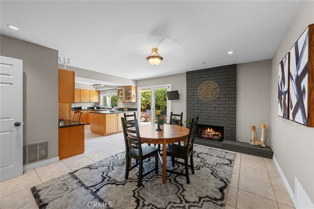 dining area with light tile patterned flooring, a brick fireplace, visible vents, and recessed lighting