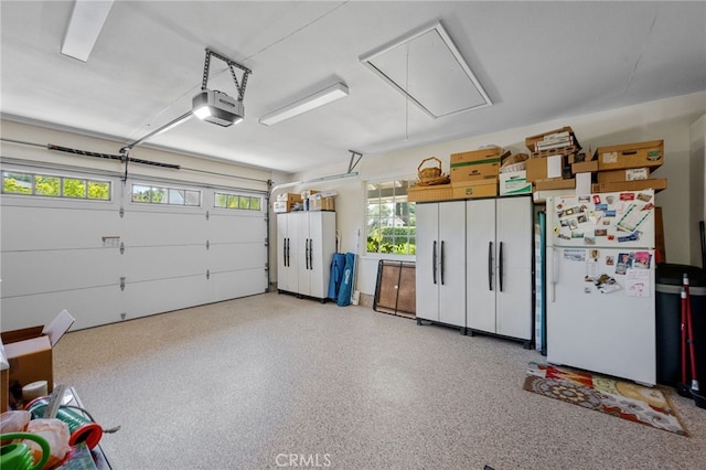 garage with freestanding refrigerator and a garage door opener