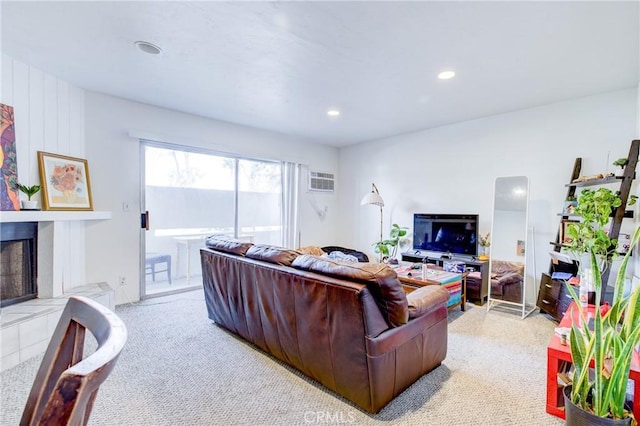 living room featuring recessed lighting, light carpet, and a fireplace with raised hearth