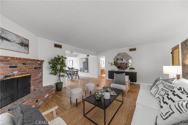 living room with visible vents, wood finished floors, and a fireplace