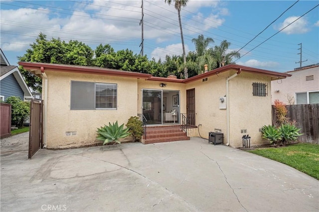 rear view of property with a patio area, crawl space, stucco siding, and fence