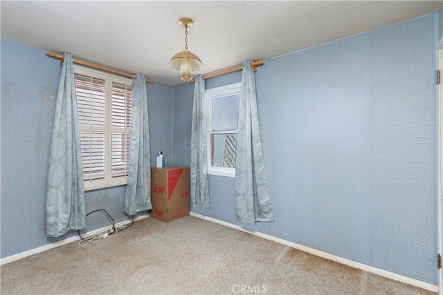 carpeted empty room featuring baseboards