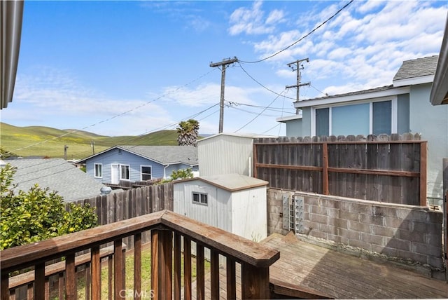 deck featuring a shed, a fenced backyard, and an outdoor structure
