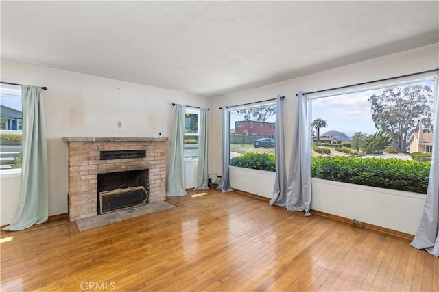 1035 Las Tunas St, Morro Bay, CA 93442 - unfurnished living room with hardwood / wood-style floors, healthy amount of natural light, a fireplace, and baseboards