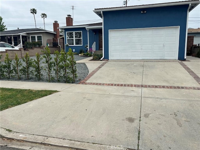 single story home with concrete driveway, a garage, and stucco siding