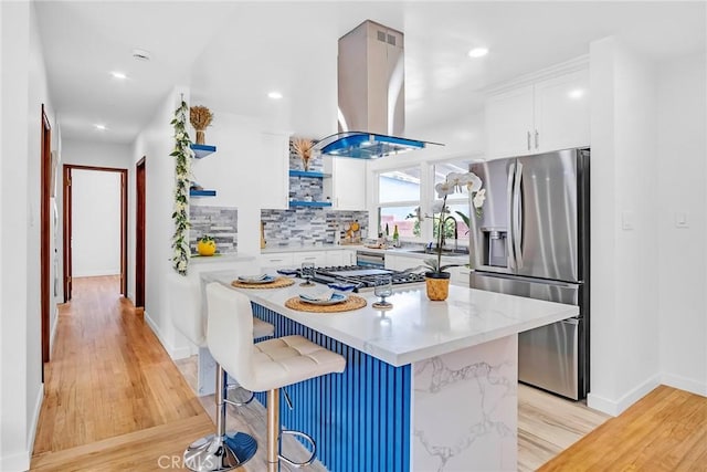 1521 249th St, Harbor City, CA 90710 - kitchen featuring appliances with stainless steel finishes, island range hood, light wood-style flooring, white cabinets, and recessed lighting