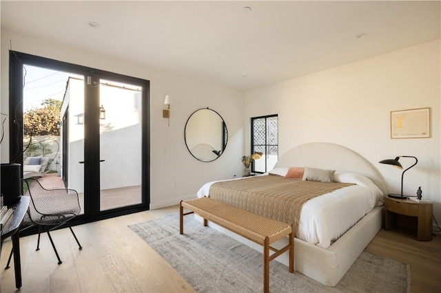 bedroom with french doors, light wood-style floors, and access to exterior