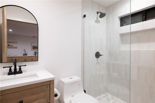 full bath featuring vanity, toilet, and tiled shower