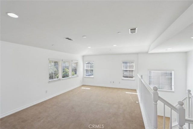 unfurnished room with recessed lighting, light carpet, visible vents, and baseboards