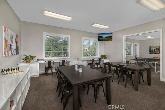 dining space featuring baseboards and dark carpet