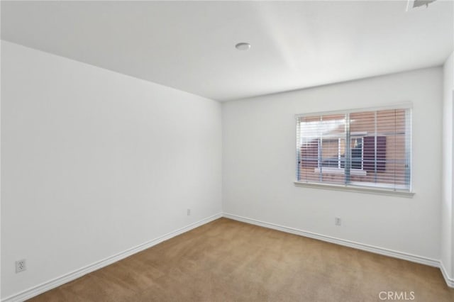 carpeted empty room with baseboards