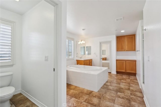 full bath featuring recessed lighting, vanity, toilet, visible vents, and a garden tub