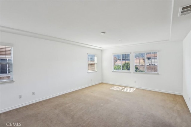 carpeted empty room featuring baseboards and visible vents