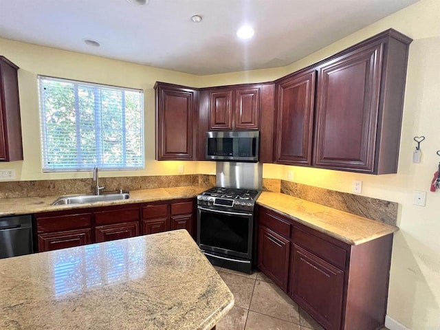 kitchen with stainless steel appliances, dark brown cabinets, light tile patterned flooring, and a sink