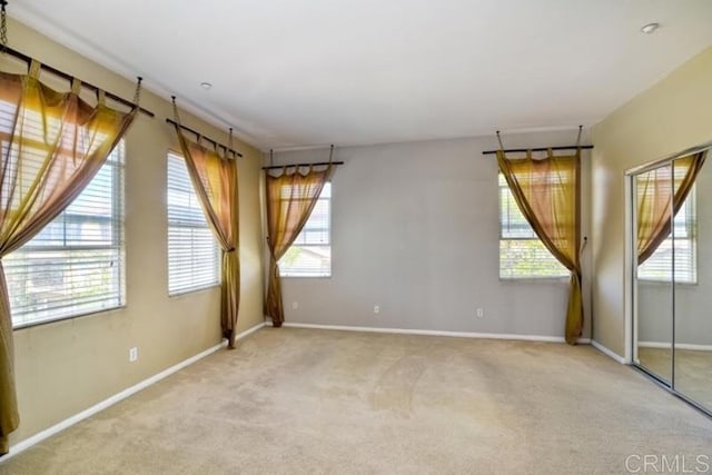 carpeted empty room featuring baseboards