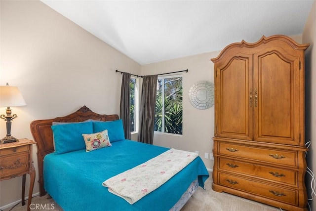 bedroom with lofted ceiling, baseboards, and light carpet