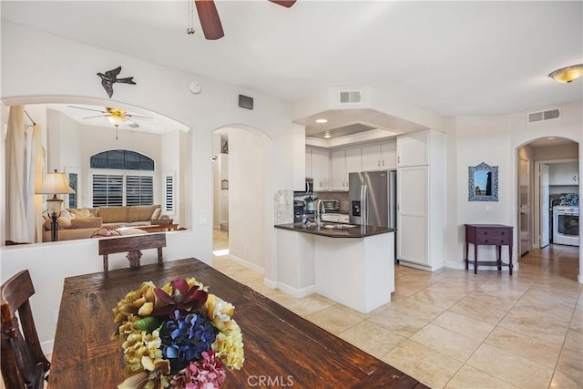 kitchen featuring arched walkways, stainless steel fridge, visible vents, and a ceiling fan