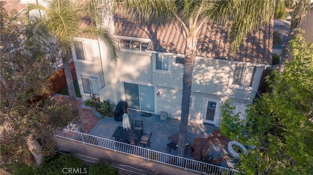 back of house featuring stucco siding, fence, and a patio