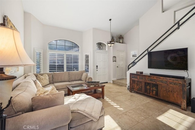living area featuring a high ceiling and stairs