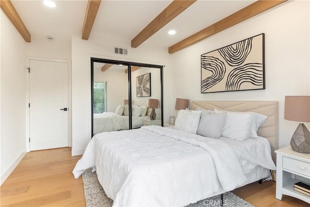 bedroom with recessed lighting, visible vents, beamed ceiling, light wood-style floors, and a closet