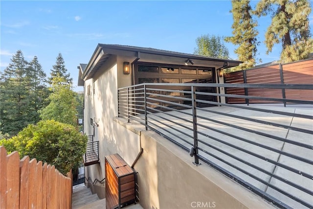 view of property exterior featuring stucco siding, an exterior structure, and concrete driveway