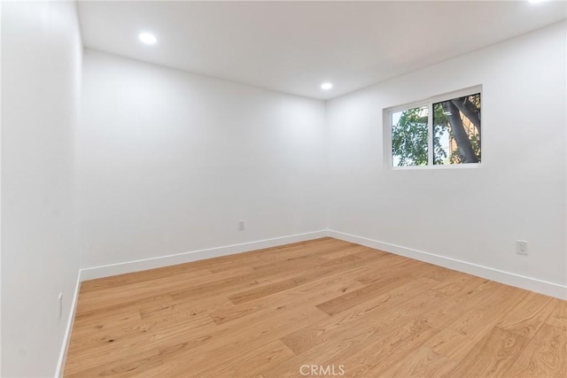 spare room with recessed lighting, light wood-type flooring, and baseboards