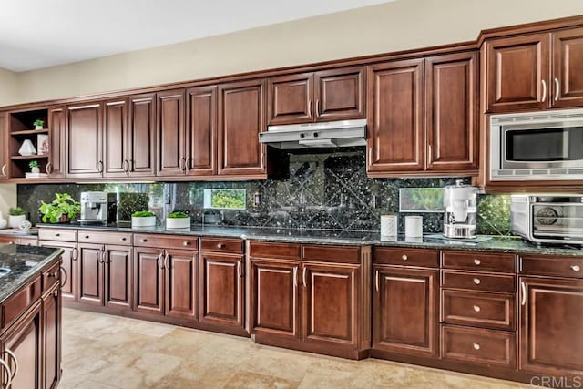 10495 Abalone Lndg, San Diego, CA 92130 - kitchen with under cabinet range hood, open shelves, stainless steel microwave, dark stone countertops, and tasteful backsplash