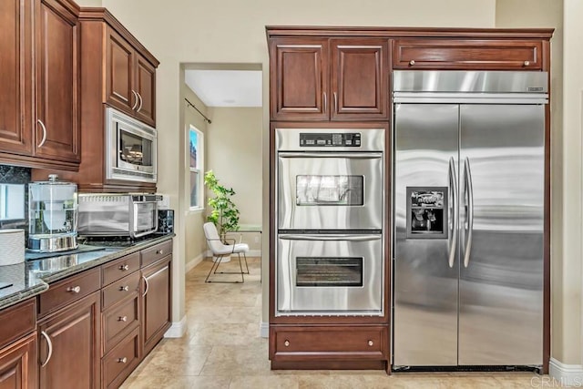10495 Abalone Lndg, San Diego, CA 92130 - kitchen featuring built in appliances, dark stone counters, backsplash, and baseboards