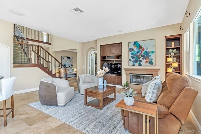 10495 Abalone Lndg, San Diego, CA 92130 - living area with stairway, arched walkways, baseboards, and a glass covered fireplace