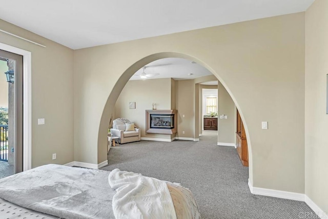 10495 Abalone Lndg, San Diego, CA 92130 - carpeted bedroom with a glass covered fireplace, baseboards, access to outside, and arched walkways