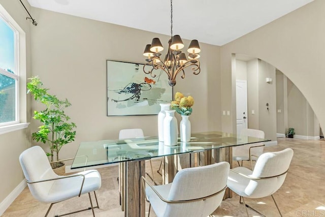 10495 Abalone Lndg, San Diego, CA 92130 - dining room featuring arched walkways, a chandelier, and baseboards