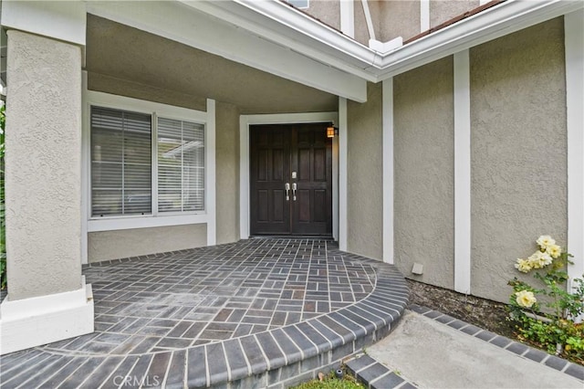 entrance to property featuring stucco siding