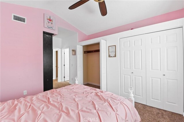 bedroom with carpet, visible vents, lofted ceiling, and two closets