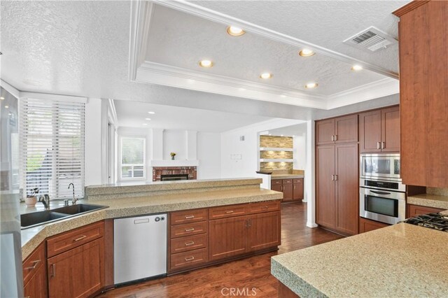 kitchen with a sink, a textured ceiling, dark wood finished floors, visible vents, and appliances with stainless steel finishes