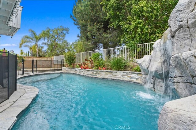 view of pool with a fenced in pool and fence