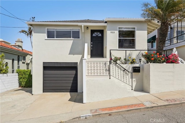 view of front facade featuring stucco siding, driveway, and a garage