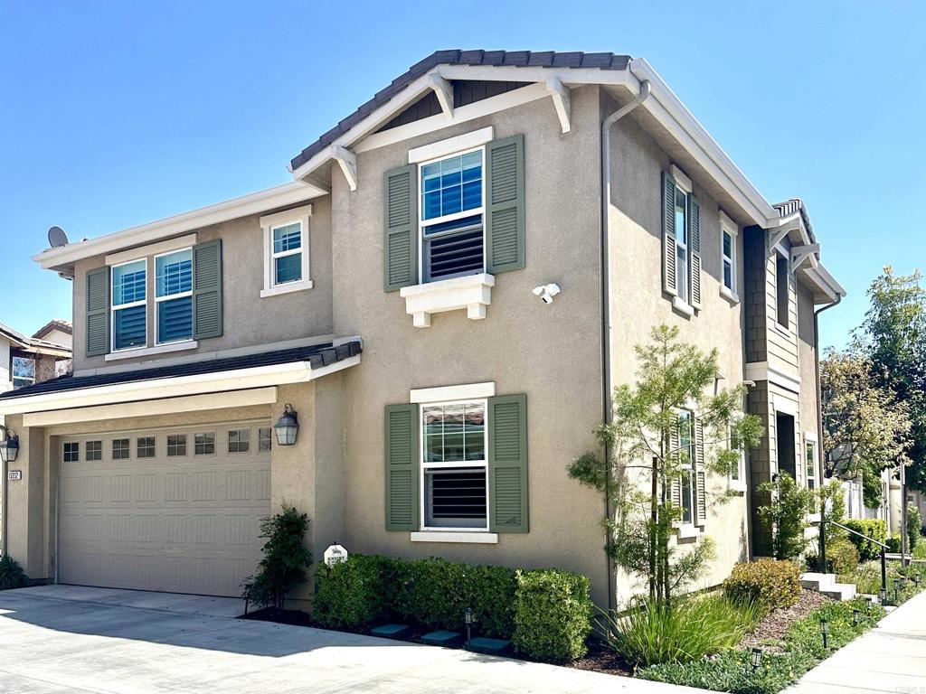 traditional-style house featuring stucco siding, driveway, and a garage