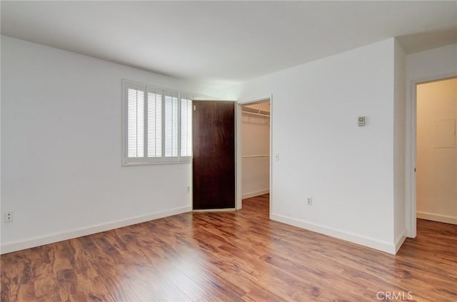 8566 Van Ness Ct Unit 21D, Huntington Beach, CA 92646 - unfurnished bedroom with wood finished floors, a spacious closet, baseboards, and a closet