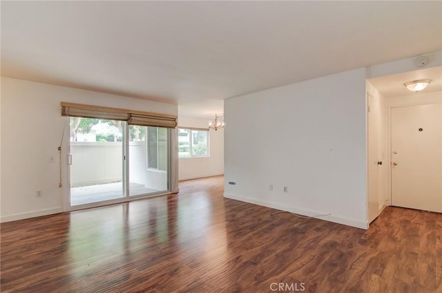 8566 Van Ness Ct Unit 21D, Huntington Beach, CA 92646 - spare room featuring a chandelier, plenty of natural light, wood finished floors, and baseboards