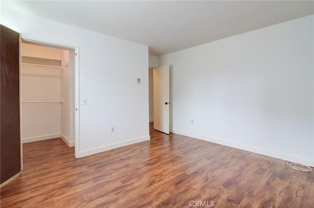 8566 Van Ness Ct Unit 21D, Huntington Beach, CA 92646 - unfurnished bedroom with wood finished floors, a walk in closet, baseboards, and a closet